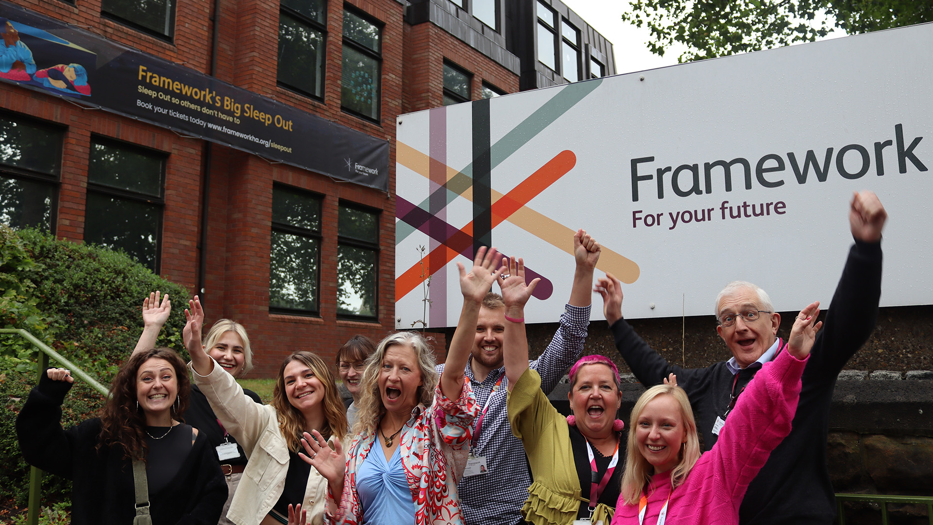 Employees from Redbrick Communications and Framework pose for a photo outside Framework's head office in Nottingham