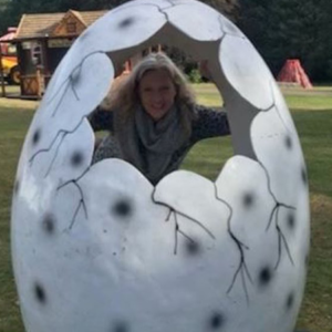 Liz poses in a giant dinosaur egg